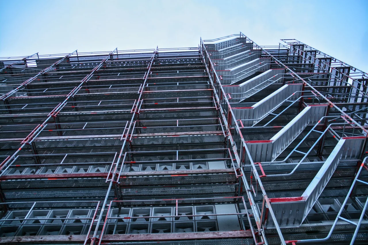 Blick von unten auf ein dichtes Baugerüst an einer Gebäudefassade